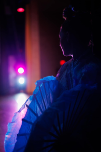 A young performer waits off stage for her cue