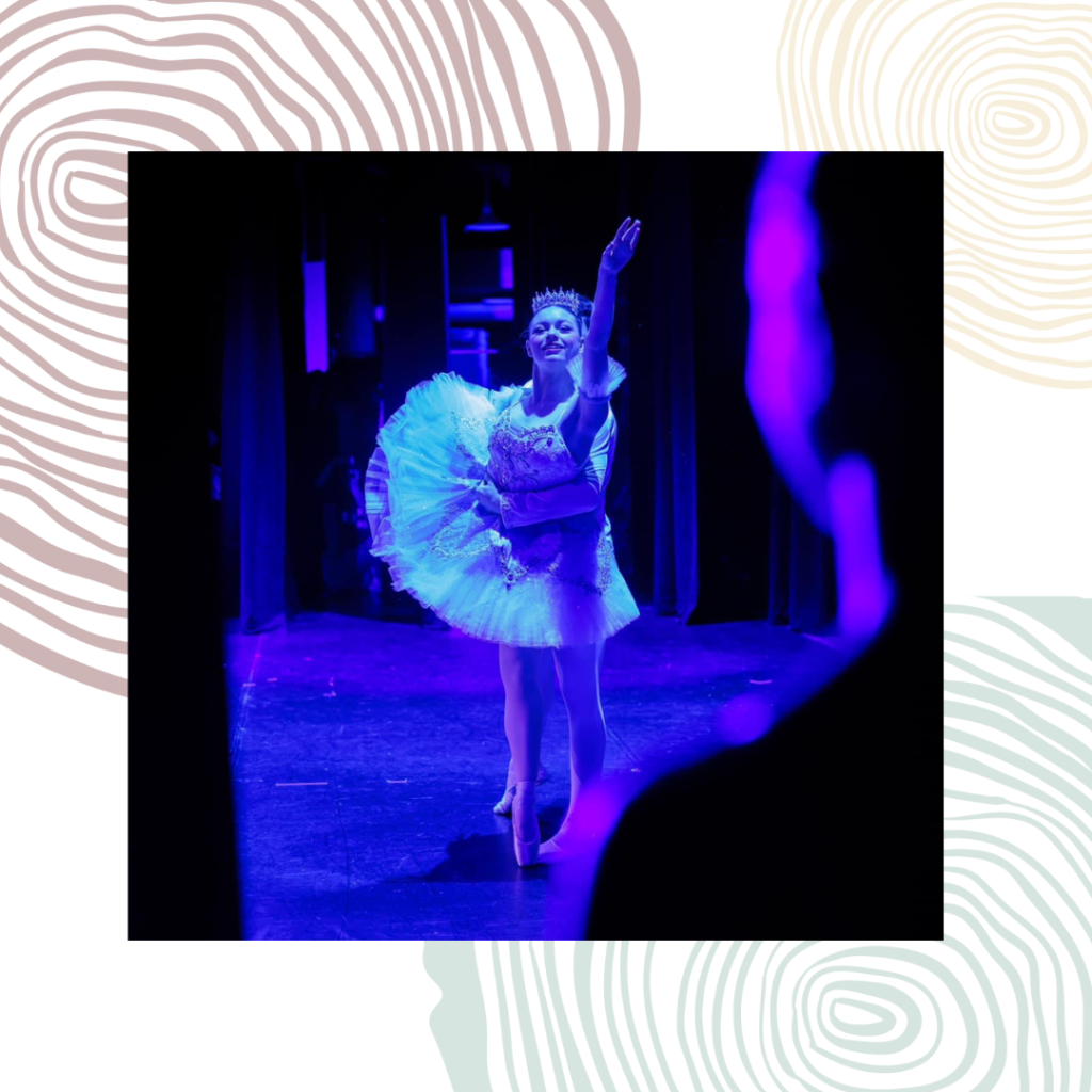 A ballerina moves on stage with blue lights