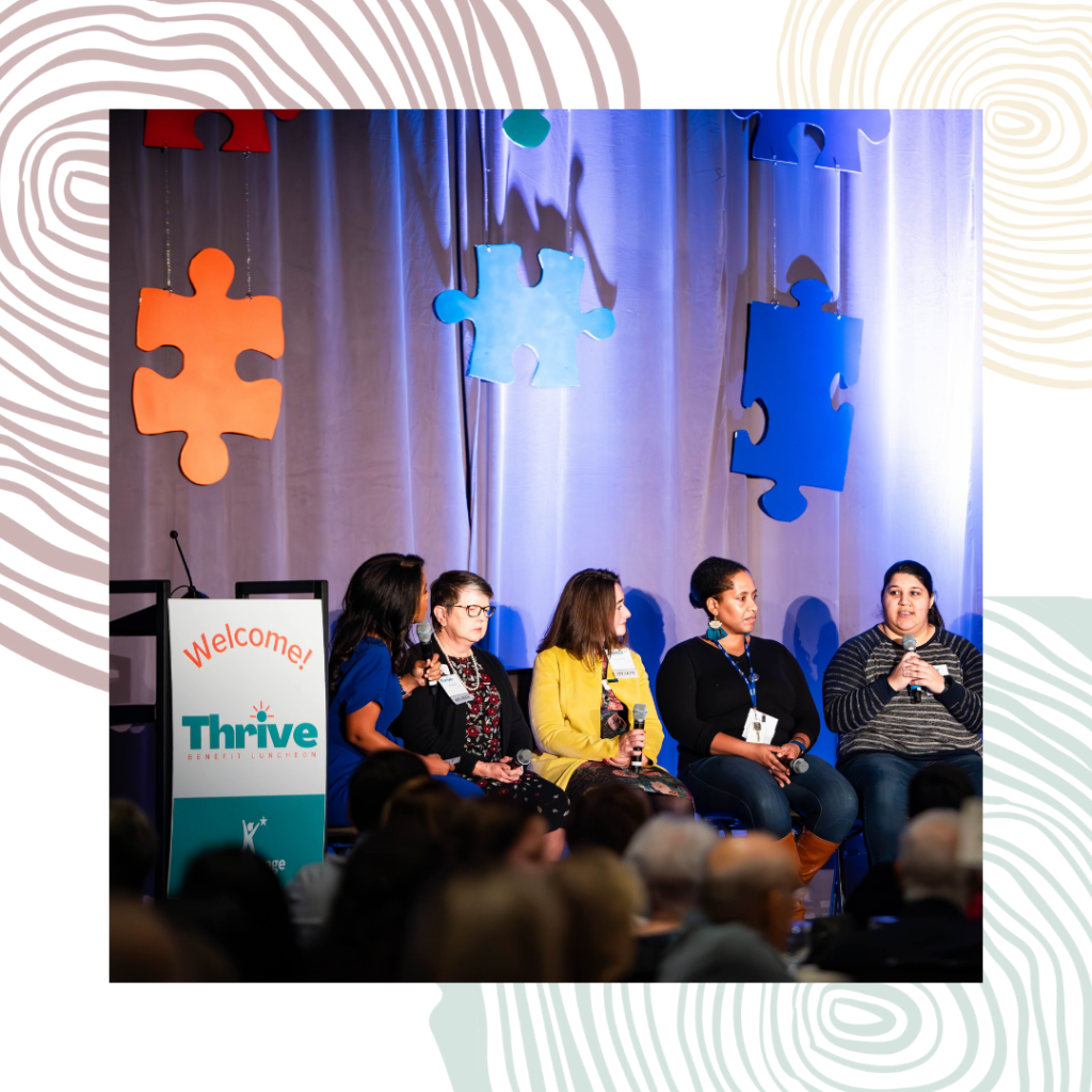 A panel of speakers sit on a stage taking turns telling stories at a benefit luncheon for KidVantage