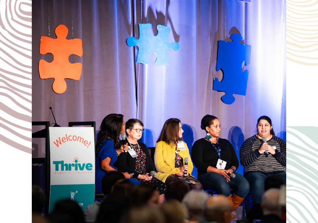 A panel of speakers sit on a stage taking turns telling stories at a benefit luncheon for KidVantage