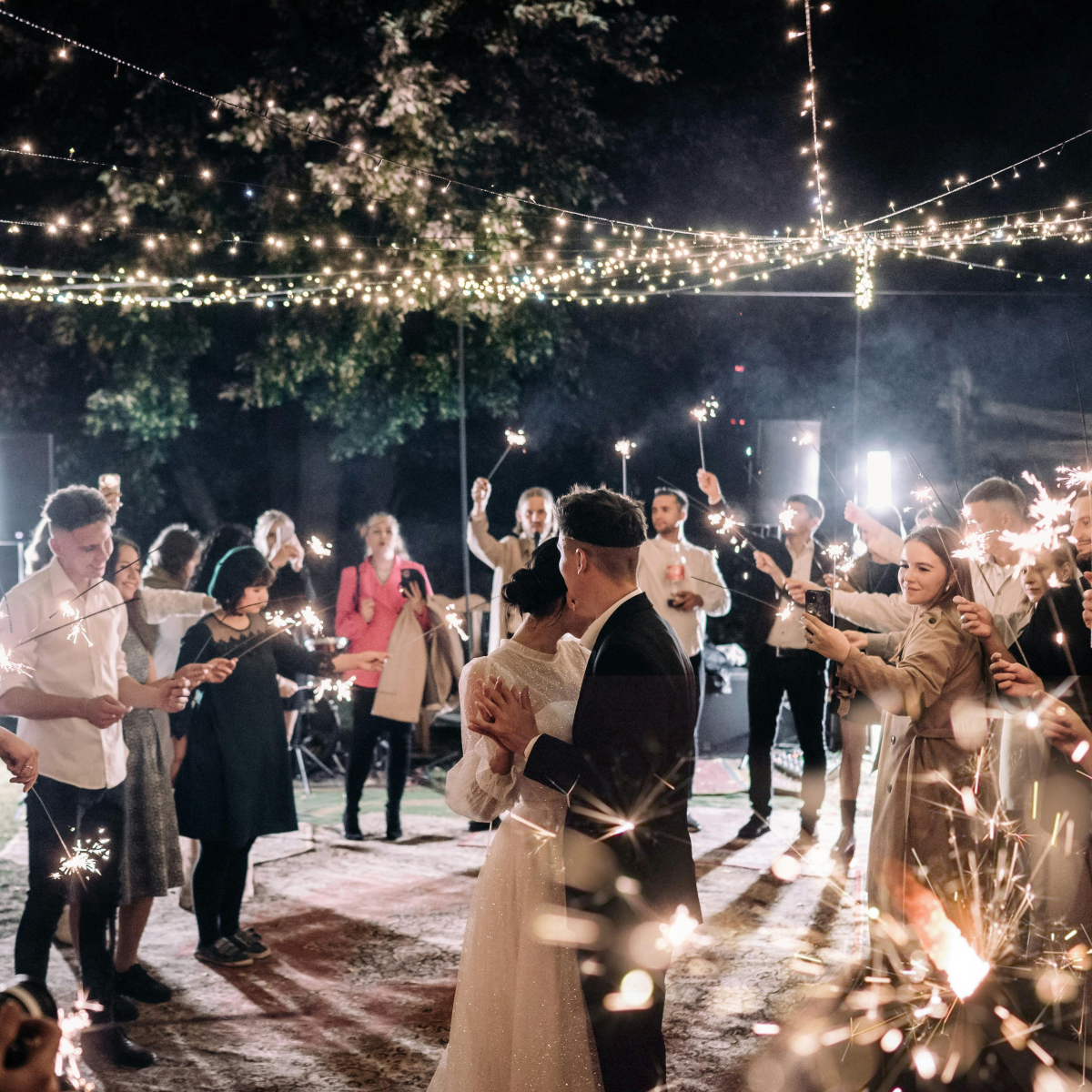Live Oak website image Wedding guests enjoy an outdoor dance floor illuminated by string lights overhead.