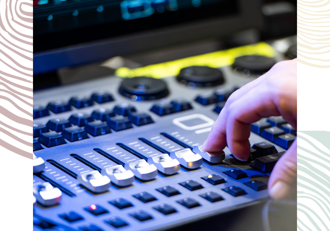 We see the hand of an AV technician using a sound mixer