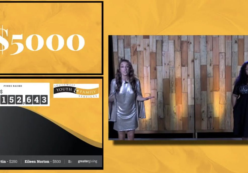 Two women stand on stage beside a wooden backdrop at the Southwest Youth & Family Services record-breaking fundraiser. Next to them, a screen displays $5,000, a fundraising total of $152,643, and donor names with their contribution amounts.
